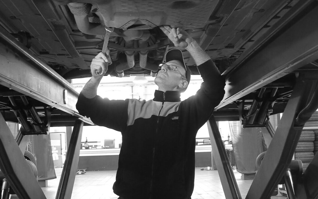 Mechanic under a vehicle on a lift