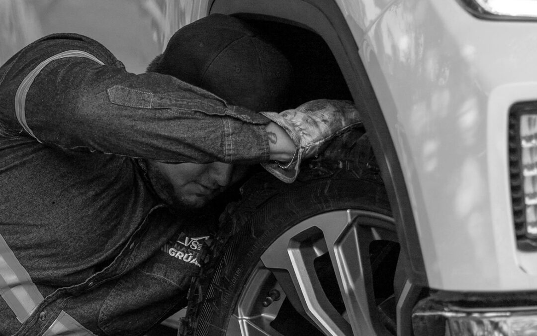 Roadside Assistance changing a truck tire on the side of the road